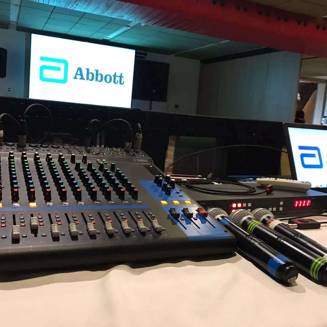 Mesa de som e microfones preparados para um evento corporativo